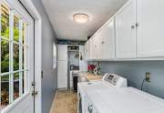Utility room with laundry, ample storage and access to the garage and back yard